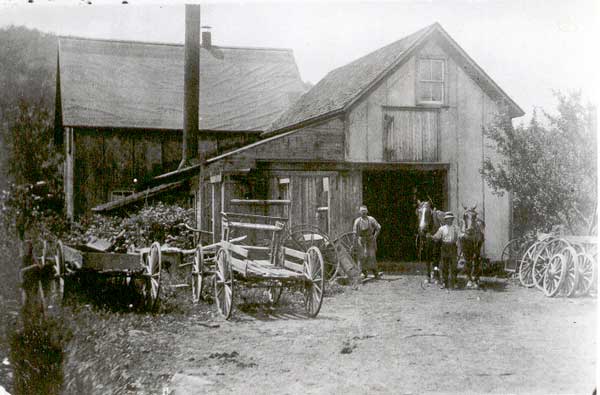 George Young in front of Blacksmith Shop